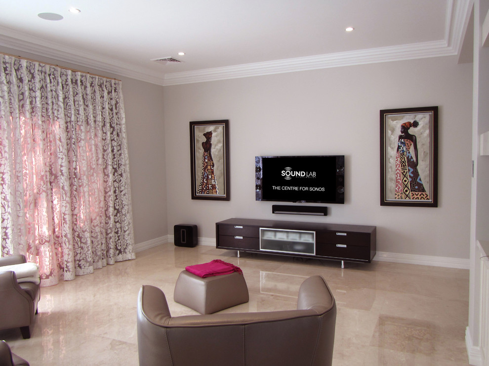 Modelo de cine en casa abierto actual de tamaño medio con paredes blancas, suelo de mármol y televisor colgado en la pared
