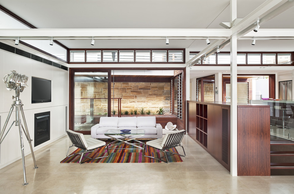 Modern inredning av ett mellanstort öppen hemmabio, med vita väggar, travertin golv och en inbyggd mediavägg