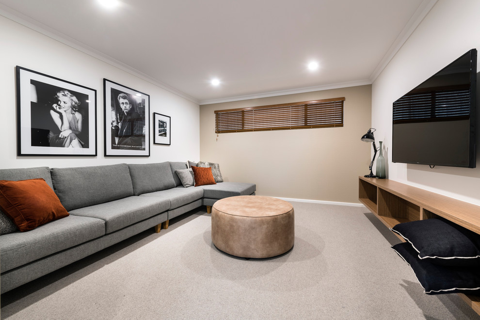 Idee per un home theatre minimalista aperto con pareti beige, moquette, TV a parete e pavimento beige