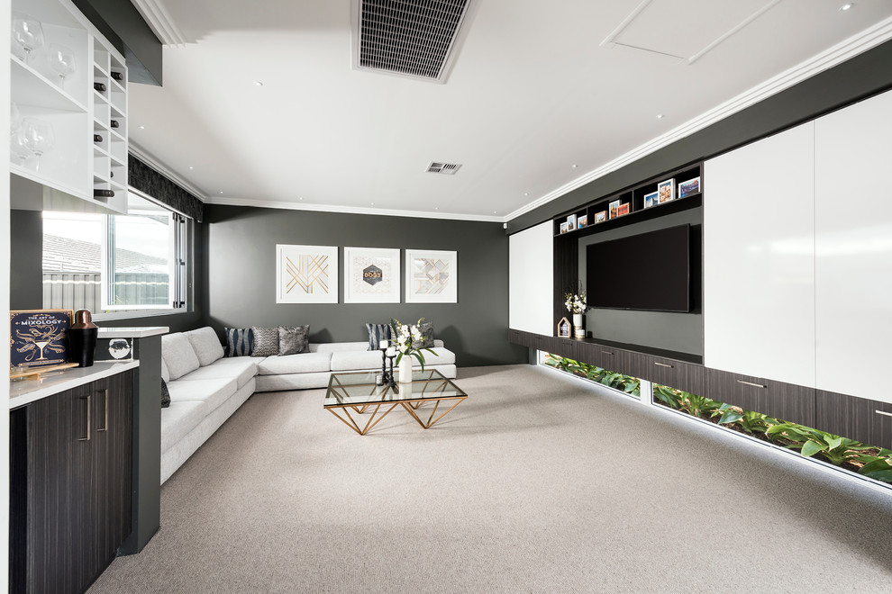 Modelo de cine en casa abierto tradicional renovado grande con paredes negras, moqueta y televisor colgado en la pared