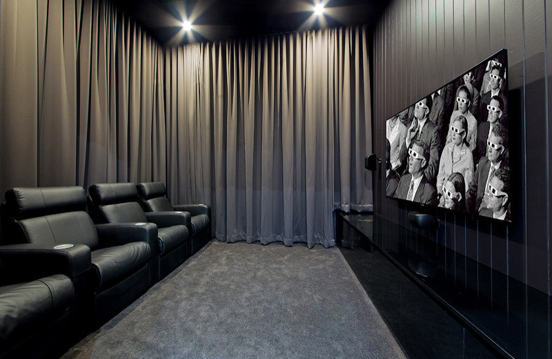 Mittelgroßes, Abgetrenntes Modernes Heimkino mit schwarzer Wandfarbe, Teppichboden und TV-Wand in Brisbane