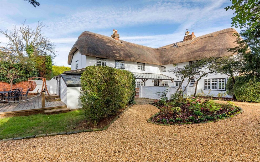 White and medium sized rural two floor detached house in Dorset with a hip roof.