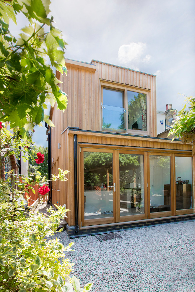Mittelgroße, Zweistöckige Moderne Holzfassade Haus mit beiger Fassadenfarbe und Flachdach in London