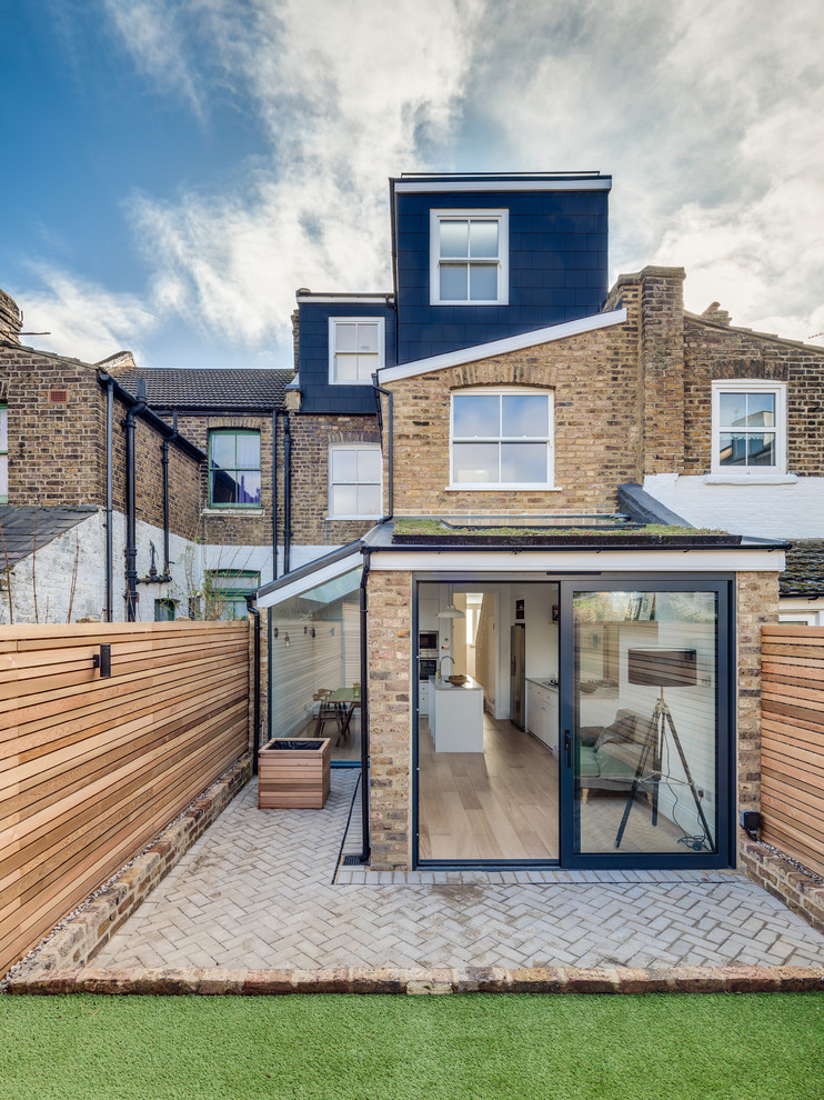 This is an example of a contemporary rear extension in London with three floors and mixed cladding.