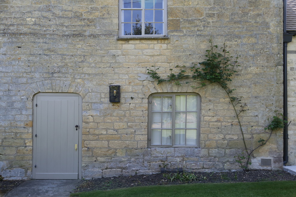 Exemple d'une façade de maison beige tendance en pierre de taille moyenne et à un étage.