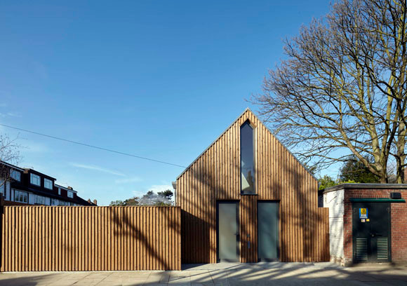 Imagen de fachada de casa marrón moderna pequeña de dos plantas con revestimiento de madera, tejado a dos aguas y tejado de varios materiales