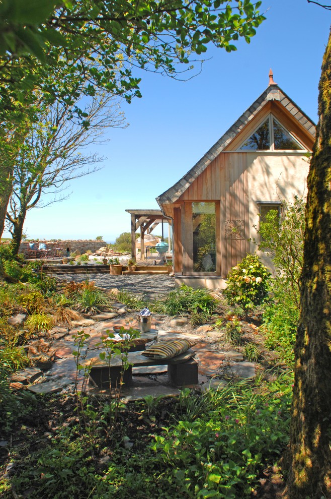 This is an example of a rustic house exterior in Devon with wood cladding and a pitched roof.