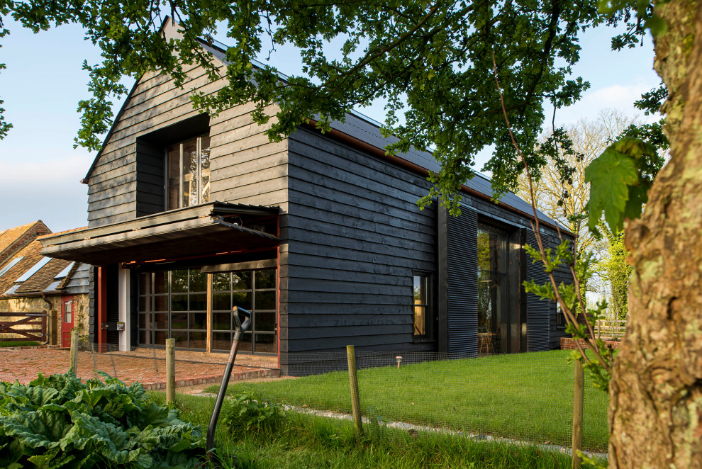 Mittelgroßes, Zweistöckiges Modernes Einfamilienhaus mit Mix-Fassade, schwarzer Fassadenfarbe, Satteldach und Misch-Dachdeckung in Kent