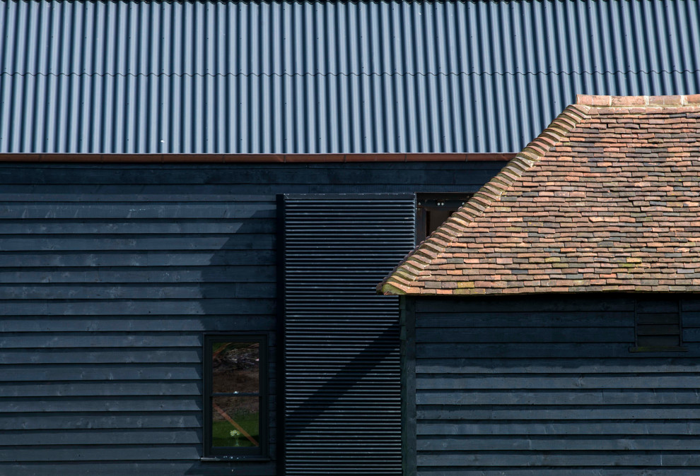 Aménagement d'une façade de maison noire contemporaine de taille moyenne et à un étage avec un revêtement mixte, un toit à deux pans et un toit mixte.