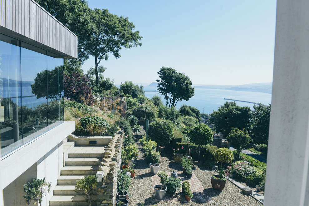 Idées déco pour une façade de maison mitoyenne bord de mer en bois de taille moyenne et à deux étages et plus avec un toit plat et un toit végétal.