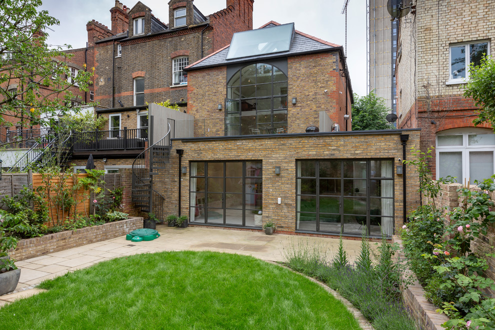 This is an example of a medium sized and beige contemporary two floor brick terraced house in London with a hip roof.