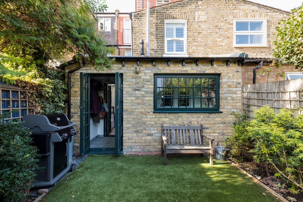 This is an example of a small and yellow industrial bungalow brick terraced house in London with a tiled roof.