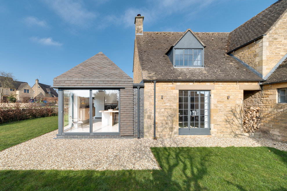 Large and beige classic two floor clay detached house in Other with a hip roof and a tiled roof.