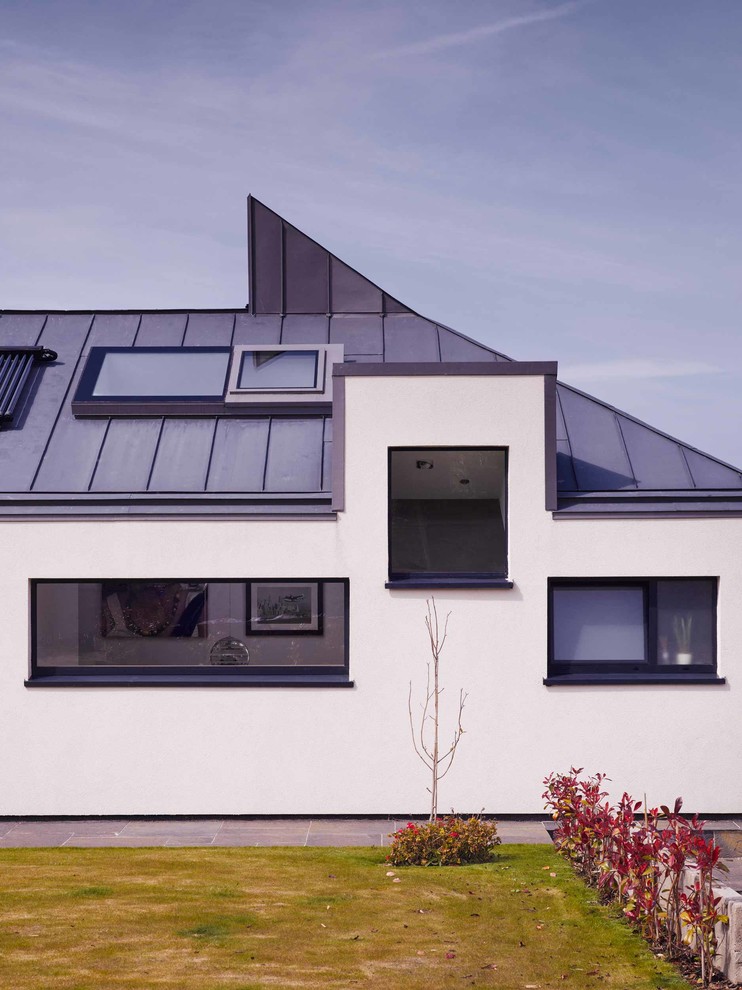Пример оригинального дизайна: большой, двухэтажный, разноцветный частный загородный дом в стиле модернизм с облицовкой из цементной штукатурки, двускатной крышей и металлической крышей