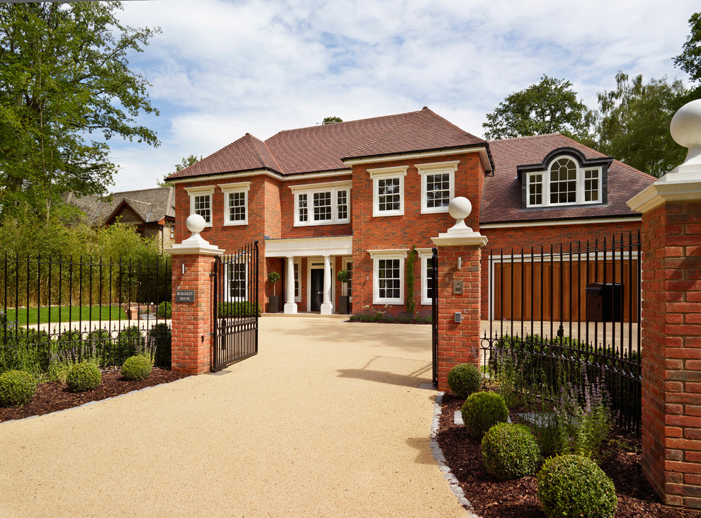 Example of a classic red two-story brick exterior home design in Essex
