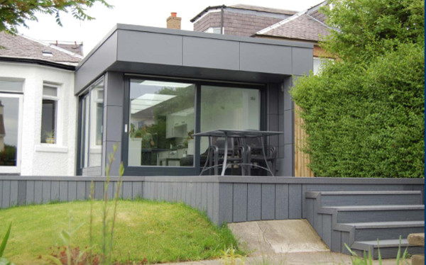 Пример оригинального дизайна: серый дом в современном стиле с облицовкой из ЦСП и плоской крышей