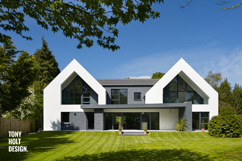 На фото: большой, двухэтажный, белый дом в современном стиле с комбинированной облицовкой с