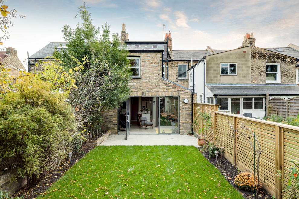 Medium sized and beige contemporary brick terraced house in London with three floors.