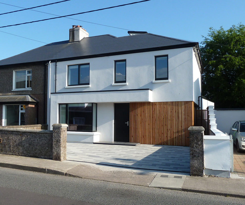 Inspiration for a medium sized and white contemporary two floor render semi-detached house in Cork with a pitched roof and a tiled roof.