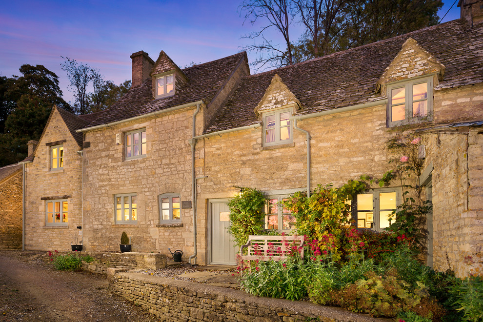 Inspiration for a large farmhouse two-story stone gable roof remodel in Gloucestershire