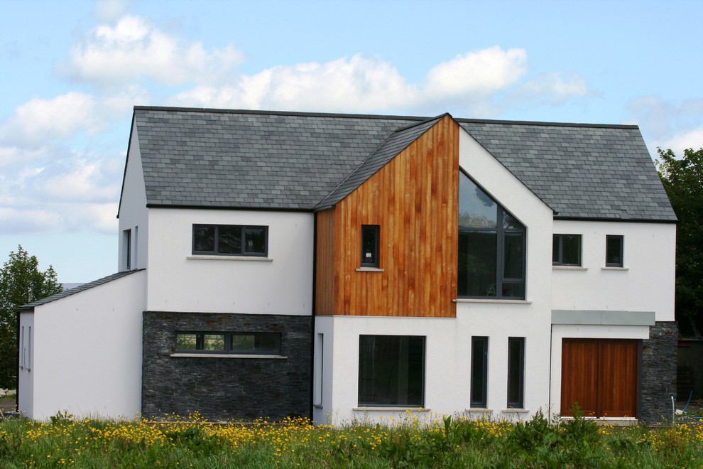 Large contemporary two floor house exterior in Other with mixed cladding and a pitched roof.