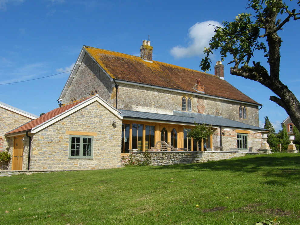Esempio della facciata di una casa country con rivestimento in pietra