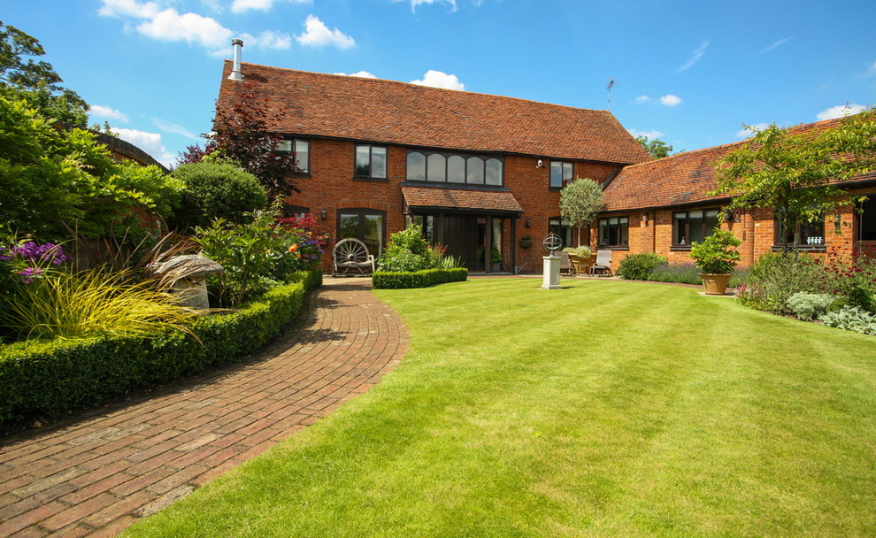 This is an example of a large farmhouse two floor brick house exterior in Cheshire with a pitched roof.