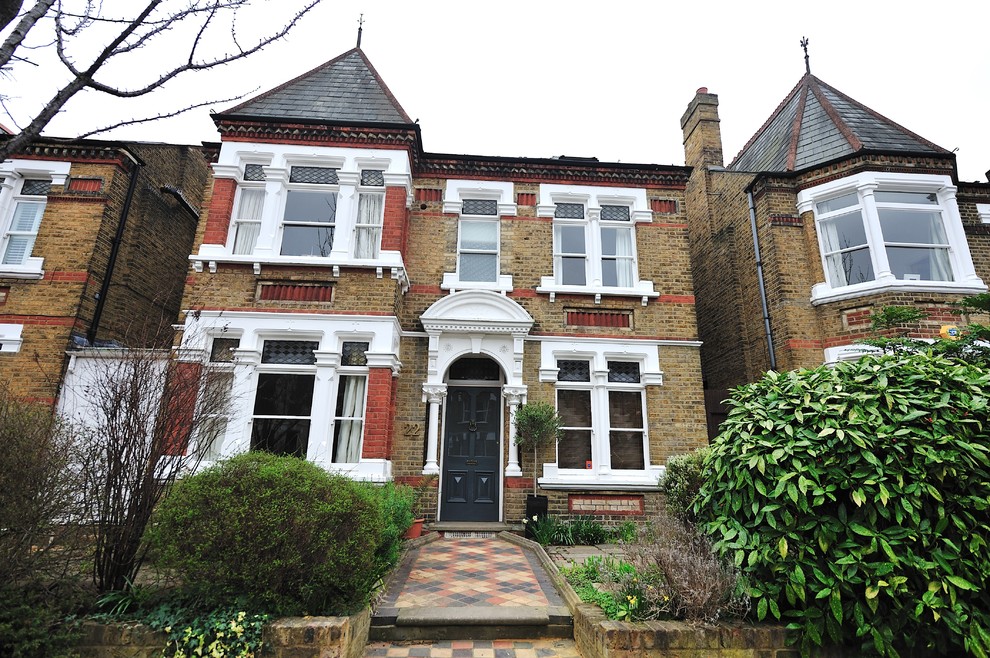 Design ideas for a medium sized victorian brick house exterior in Surrey with three floors and a pitched roof.