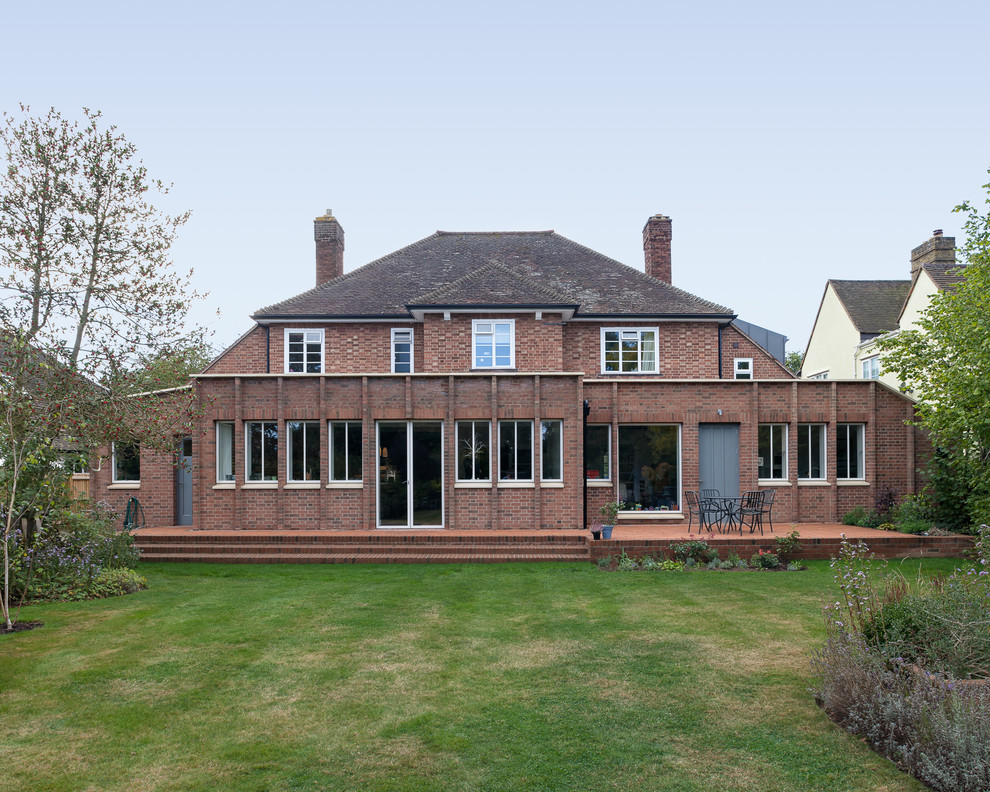 Пример оригинального дизайна: кирпичный, красный дом среднего размера в современном стиле