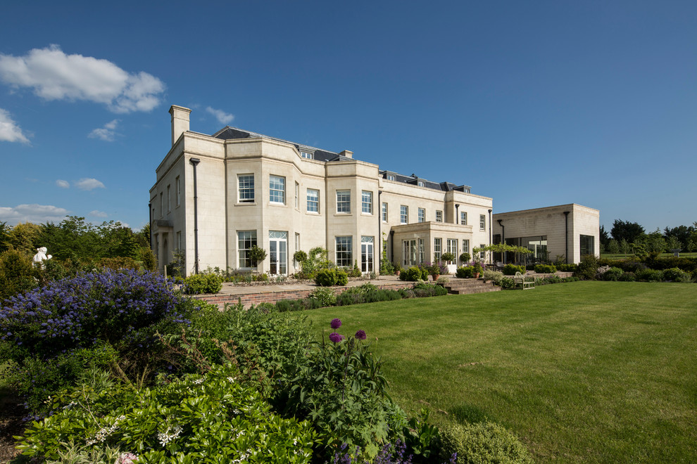 Expansive and white traditional render house exterior in Hampshire with three floors and a mansard roof.