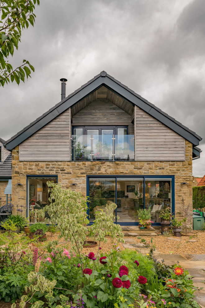 Idée de décoration pour une façade de maison design en bois et planches et couvre-joints à un étage avec un toit à deux pans et un toit en tuile.