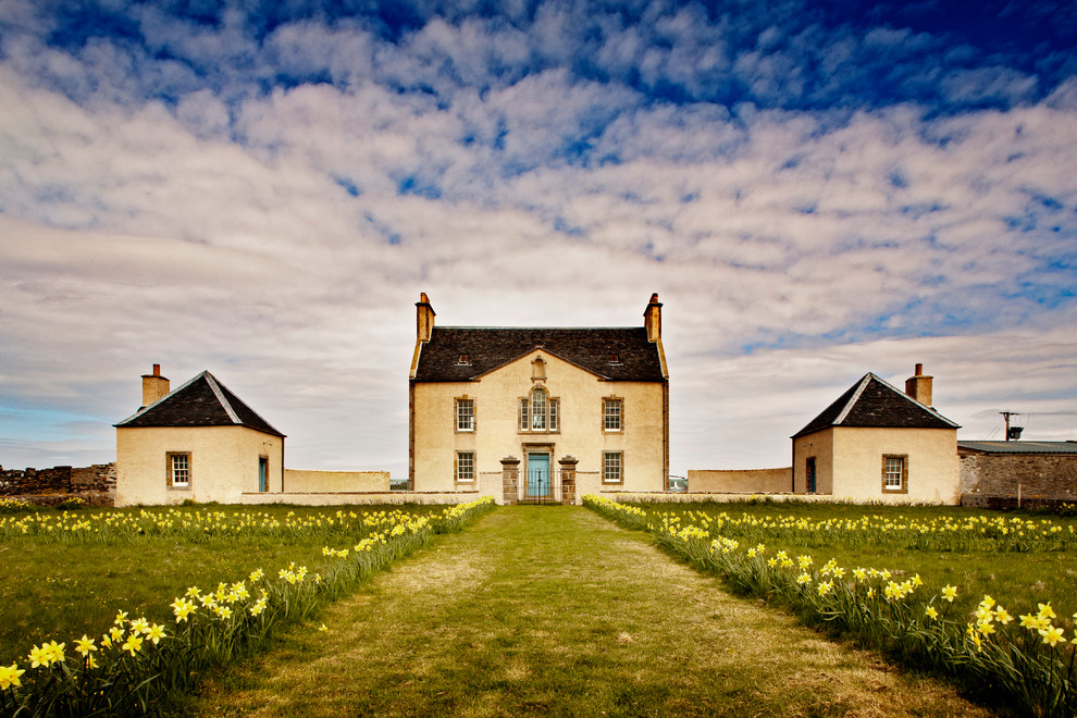 Inspiration pour une façade de maison rustique en stuc de taille moyenne et à deux étages et plus avec un toit à deux pans.