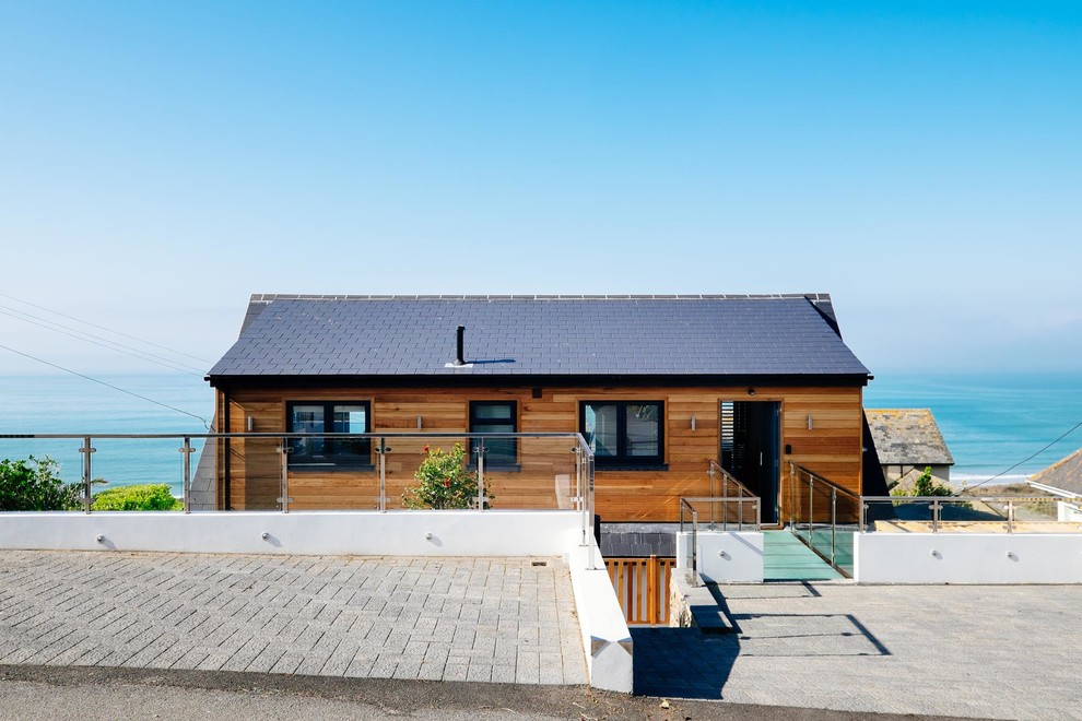 Aménagement d'une façade de maison marron contemporaine en bois avec un toit à deux pans.