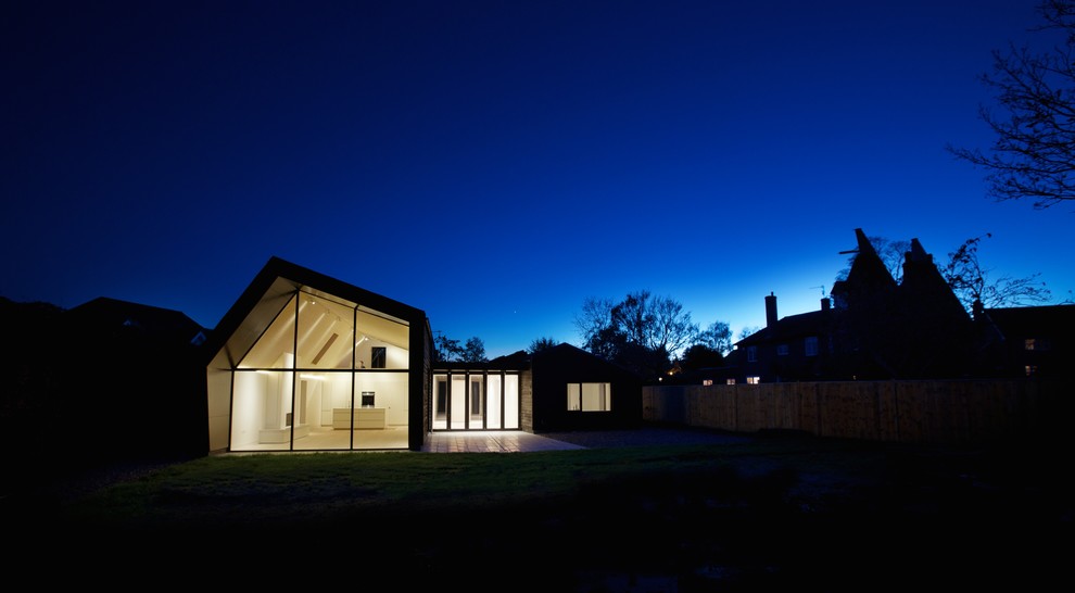 Cette photo montre une façade de maison noire tendance en bois de taille moyenne et de plain-pied.