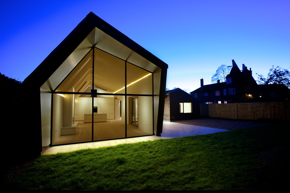 Photo of a medium sized and black contemporary bungalow house exterior in Kent with wood cladding.