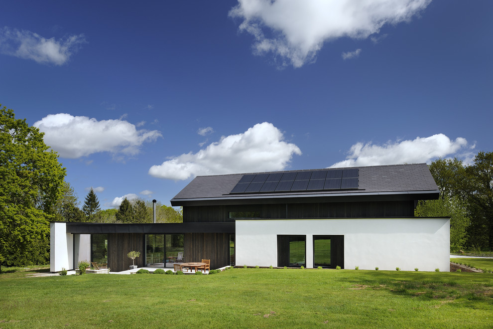 Diseño de fachada blanca contemporánea de dos plantas con tejado a dos aguas