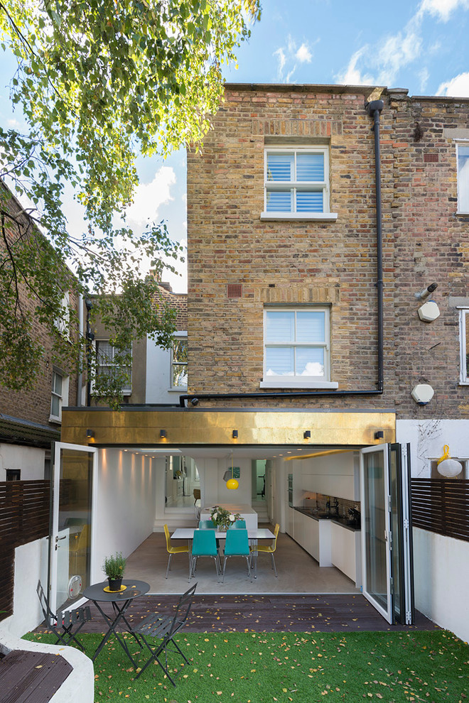Inspiration for a medium sized and beige contemporary rear house exterior in London with three floors, mixed cladding, a flat roof and a mixed material roof.