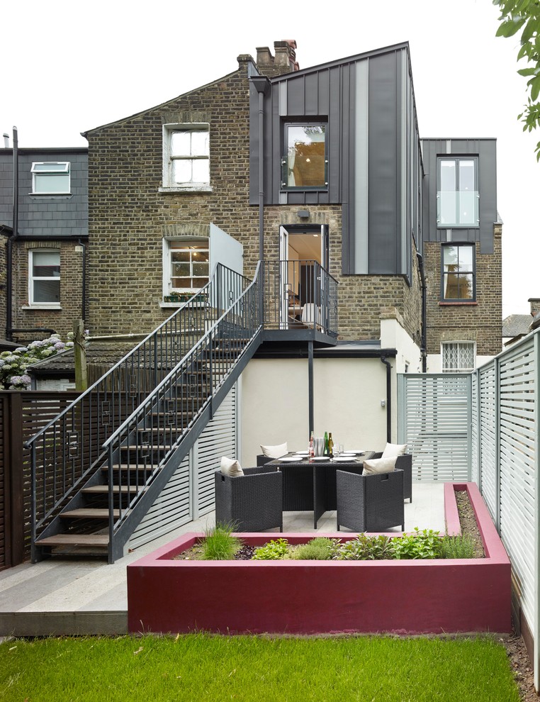 Design ideas for a medium sized and gey contemporary two floor house exterior in London with metal cladding and a lean-to roof.
