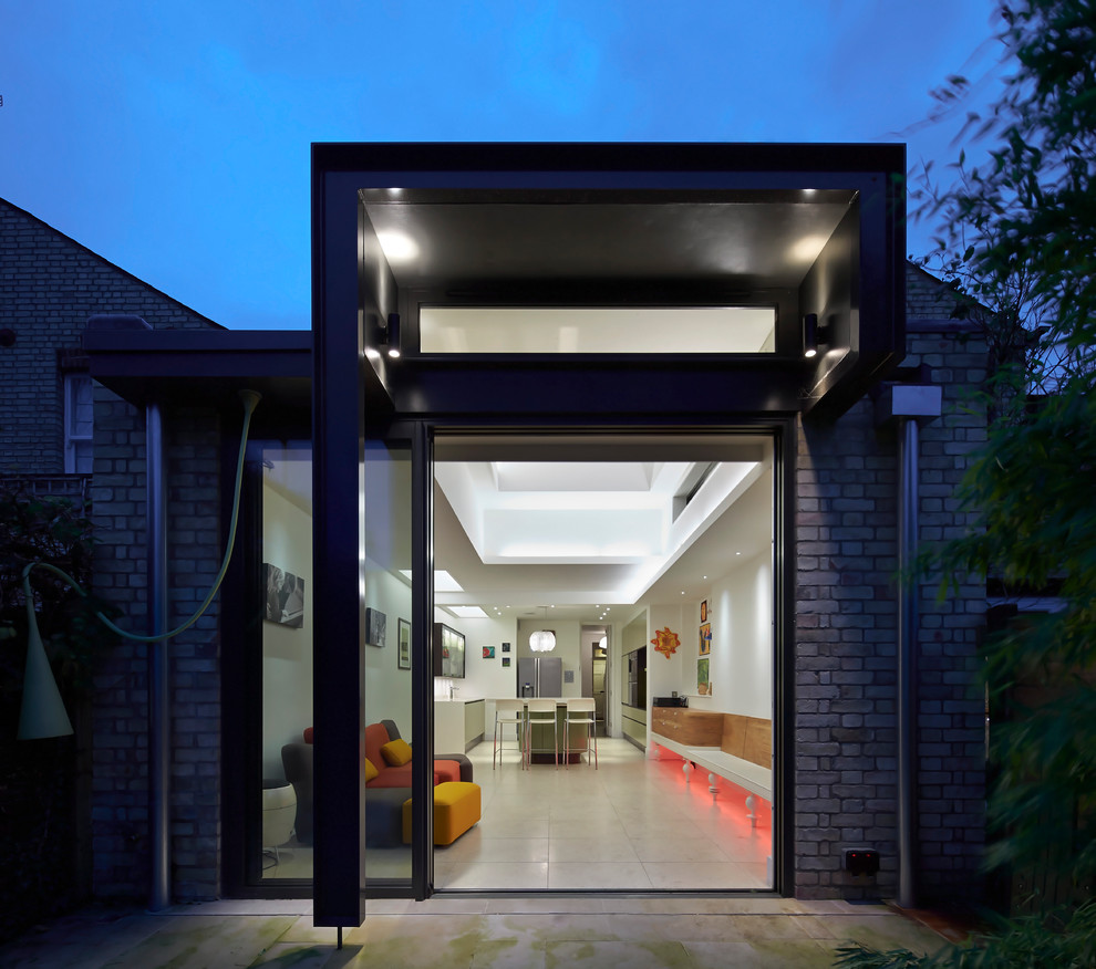 Design ideas for a black contemporary house exterior in Cambridgeshire with metal cladding and a flat roof.