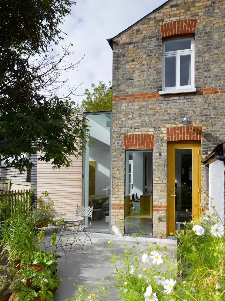 Photo of a medium sized contemporary two floor house exterior in London with mixed cladding.