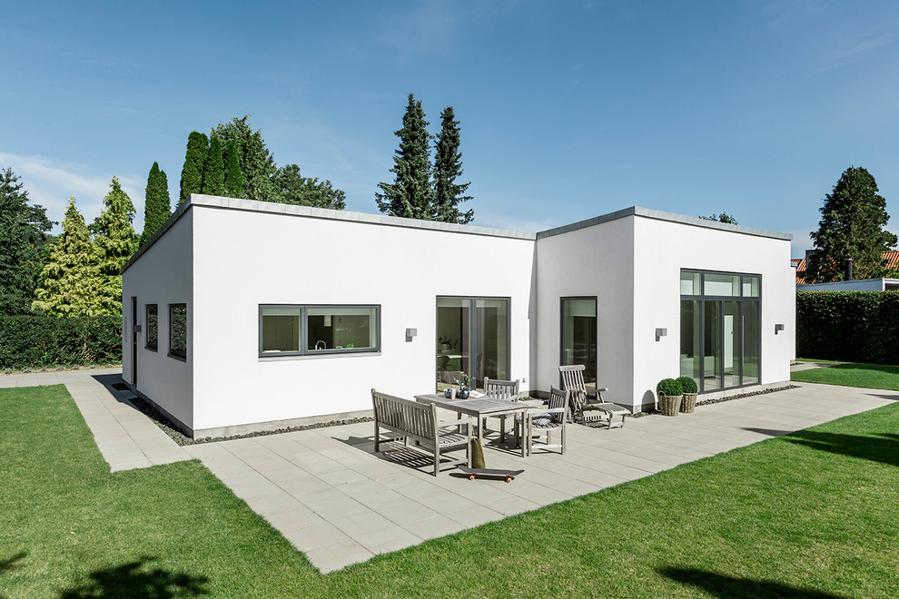 Ejemplo de fachada blanca minimalista de tamaño medio de una planta con revestimiento de hormigón y tejado plano
