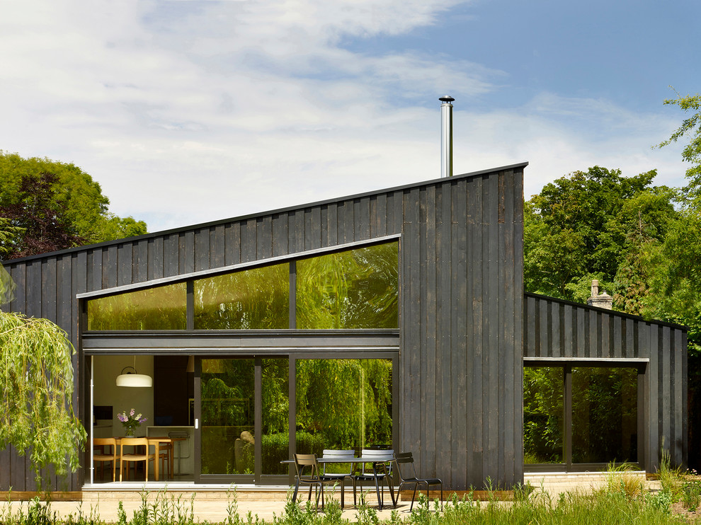 Diseño de fachada de casa negra actual de una planta con revestimiento de madera y tejado de un solo tendido