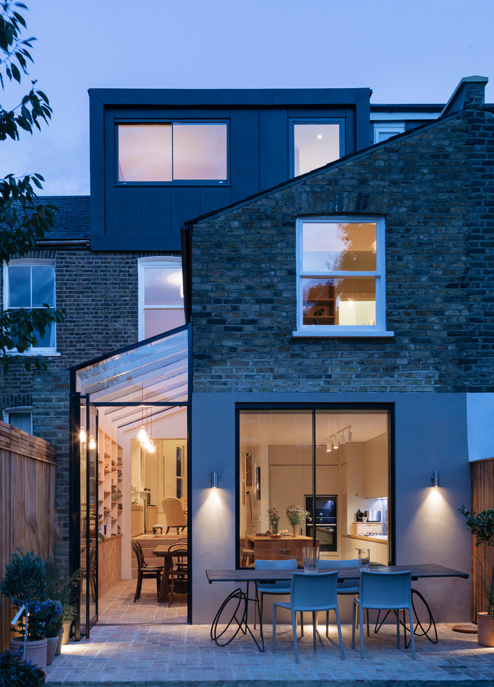 Medium sized contemporary brick terraced house in London with three floors and a flat roof.