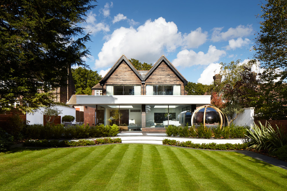 Mittelgroße Moderne Holzfassade Haus mit brauner Fassadenfarbe und Satteldach in London
