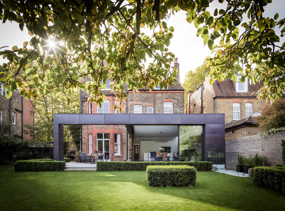 Example of a huge trendy three-story house exterior design in London