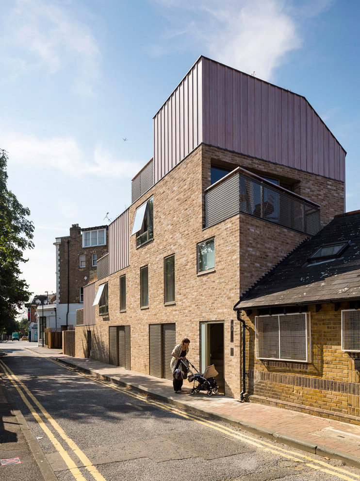 Inspiration for a small contemporary brick house exterior in London with three floors.