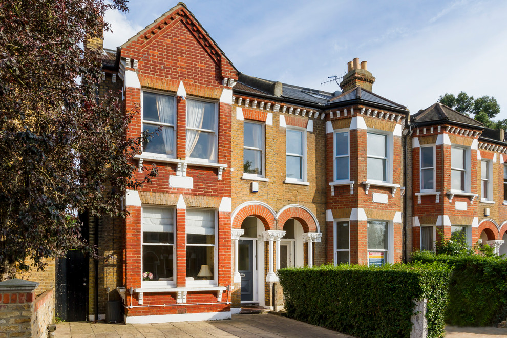 Inspiration for a red classic two floor brick terraced house in London with a pitched roof.