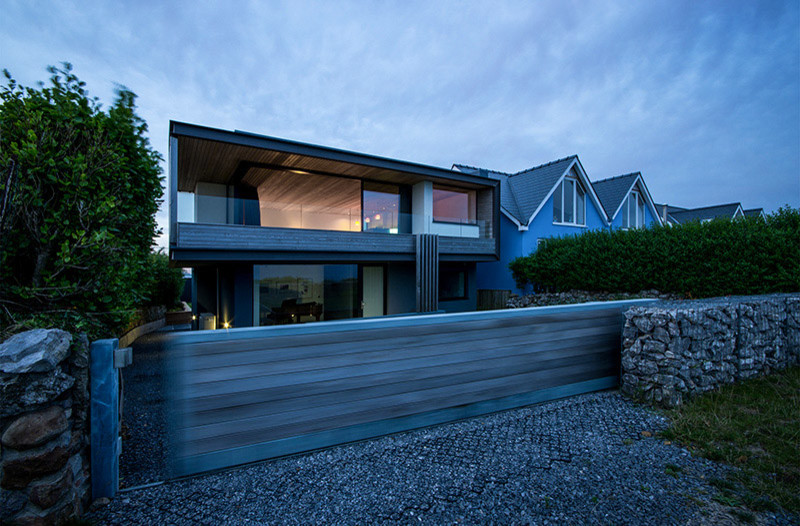 Idée de décoration pour une petite façade de maison grise design en béton à deux étages et plus avec un toit plat.