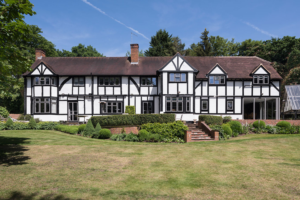 Großes, Zweistöckiges Klassisches Einfamilienhaus mit Mix-Fassade, weißer Fassadenfarbe, Halbwalmdach und Schindeldach in Surrey