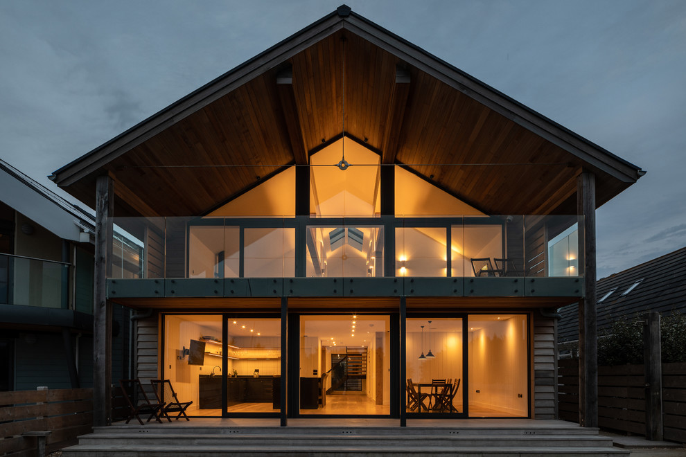 Exemple d'une grande façade de maison marron tendance en bois à un étage avec un toit à deux pans et un toit en shingle.